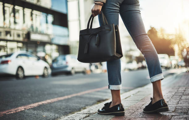 Closeup shot of a businesswoman walking with her handbag in the city